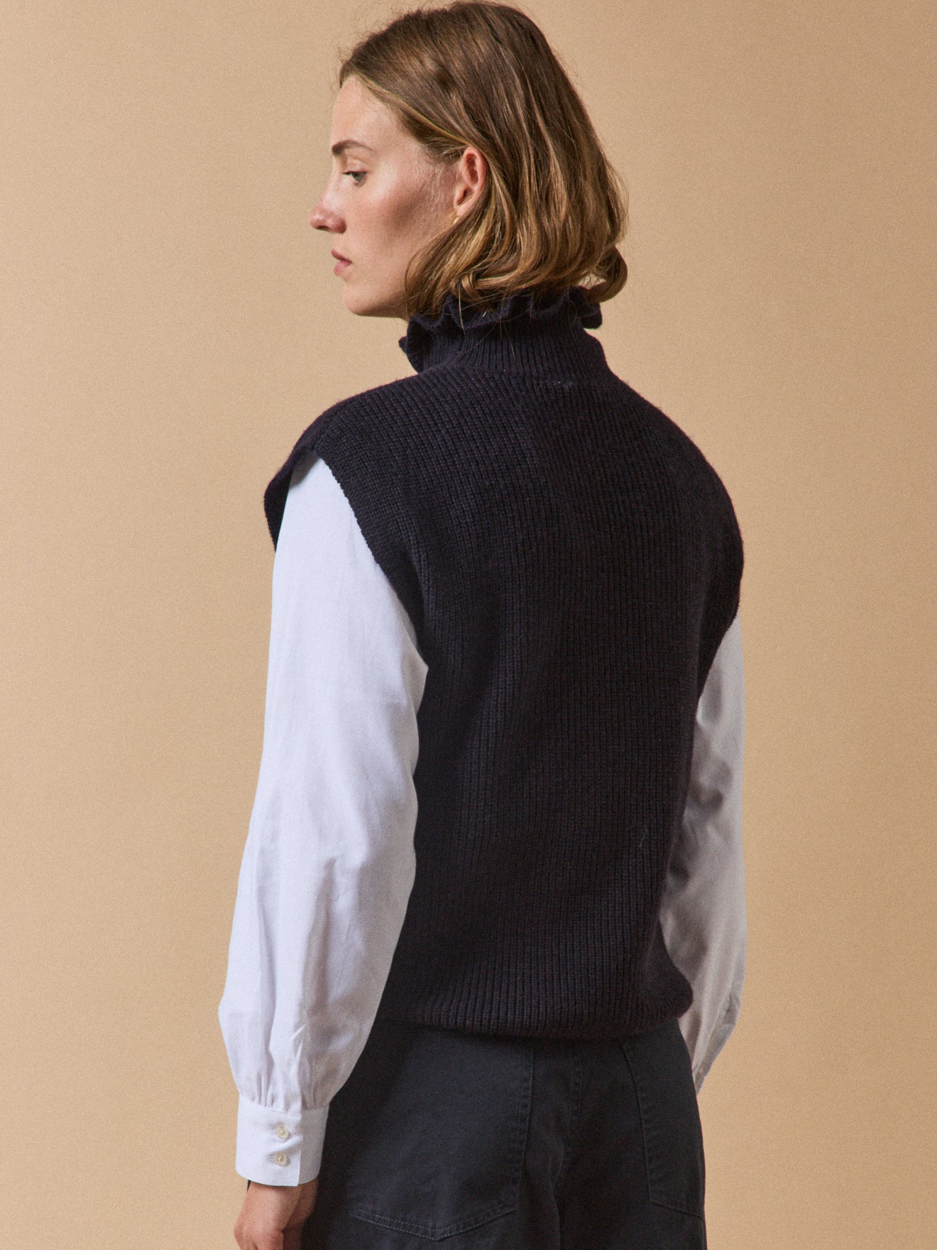 Women's sleeveless sweater with ruffled neckline