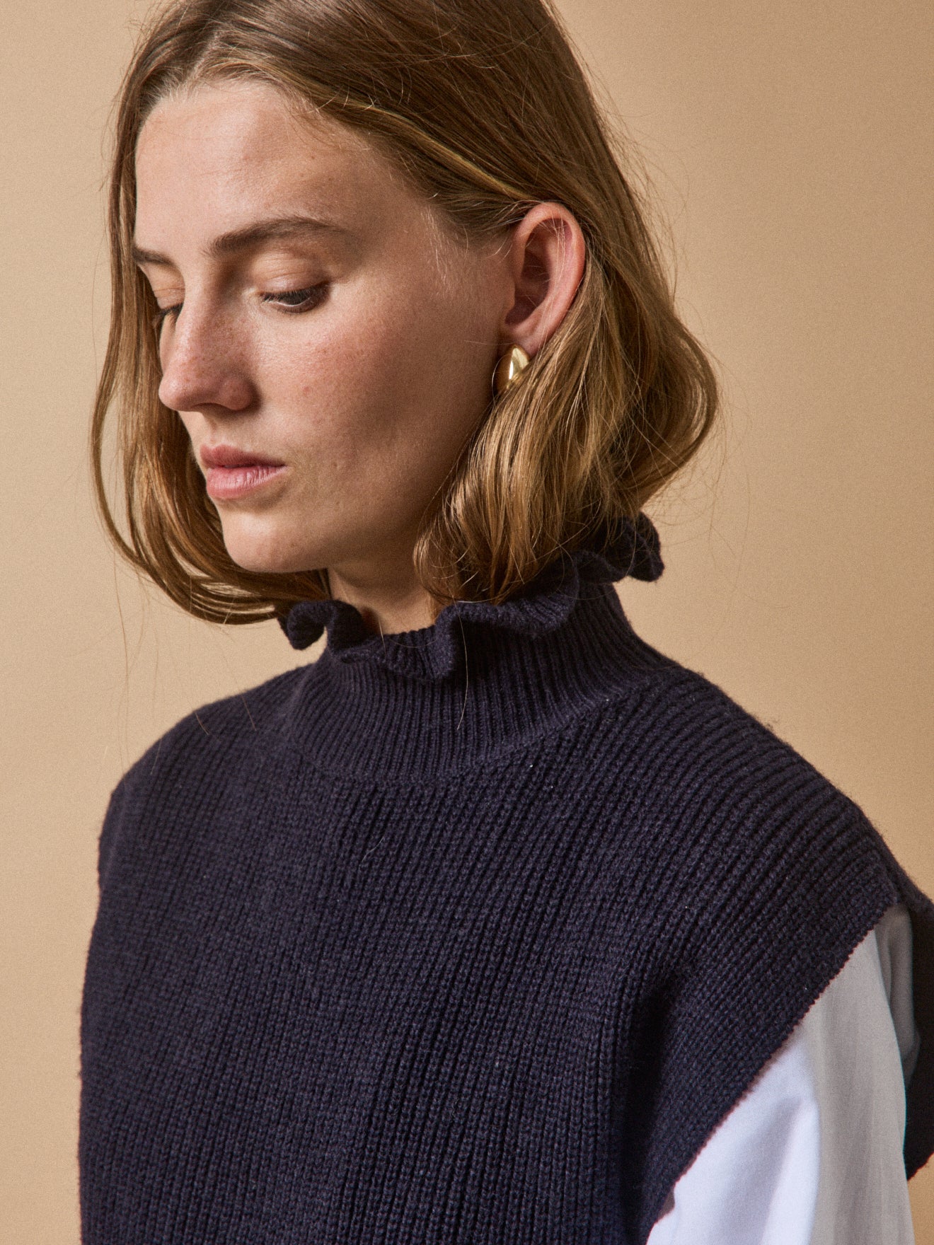 Women's sleeveless sweater with ruffled neckline