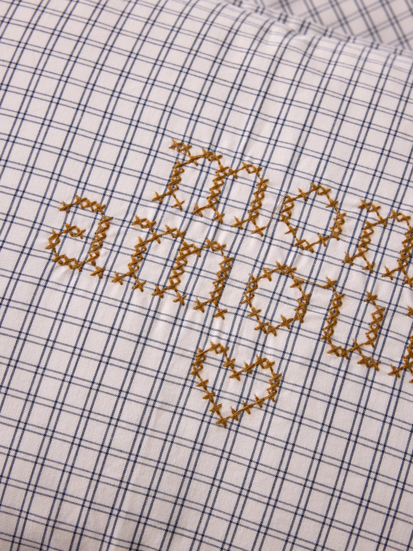 Cushion cover with small embroidered checks