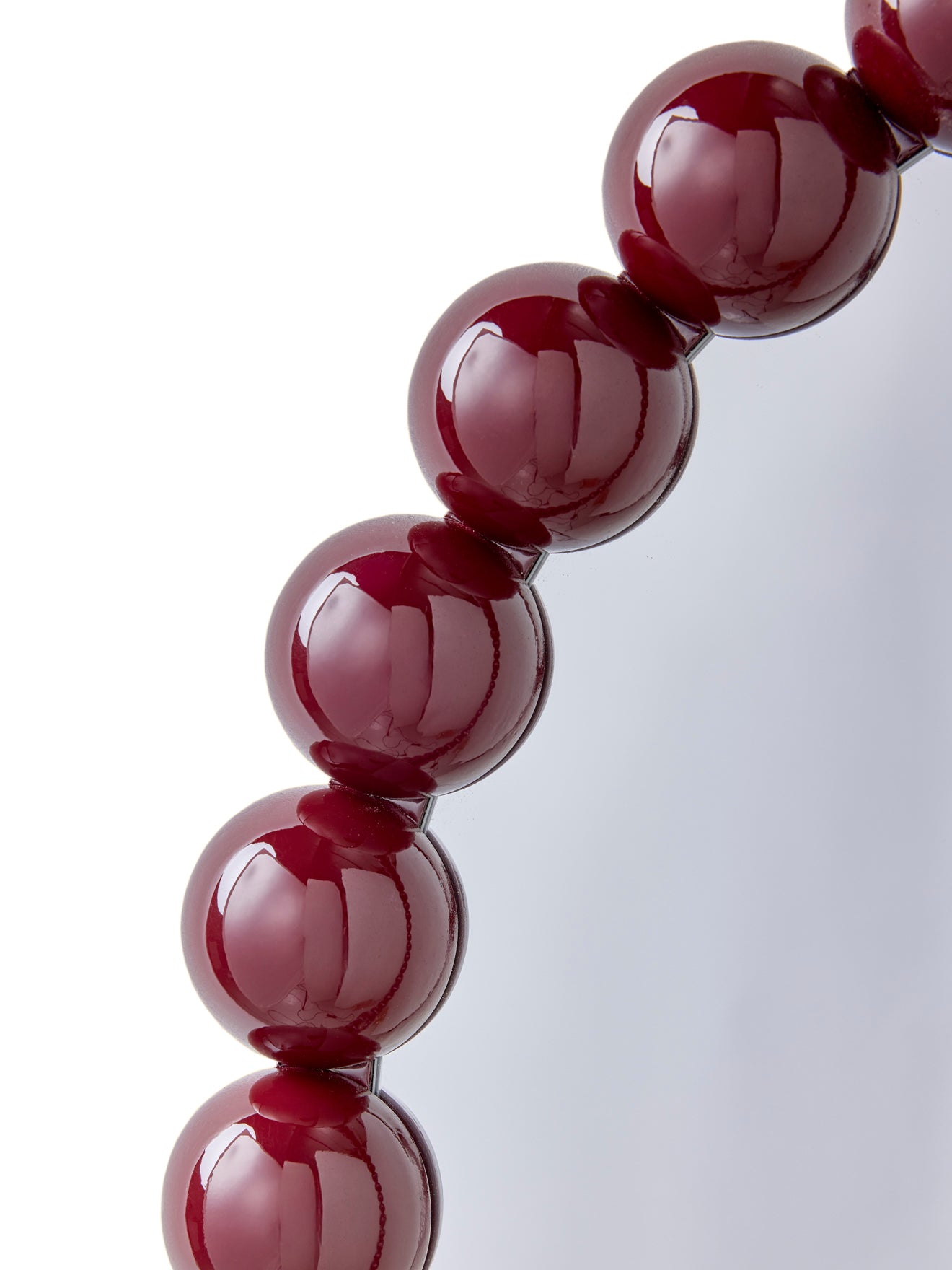 Round mirror trimmed with wooden balls