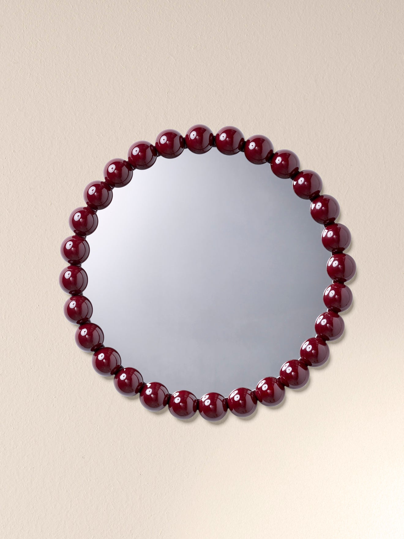 Round mirror trimmed with wooden balls