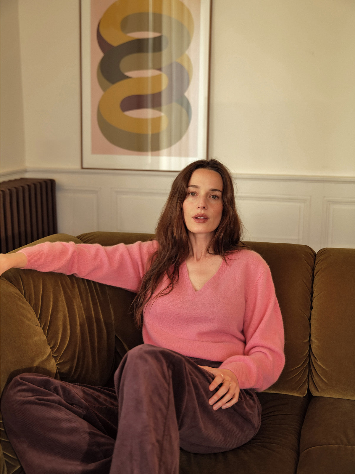 LOOKBOOK_La_Bourgogne_Femme_assise_dans_canape_avec_pull_rose_et_velours_aubergine